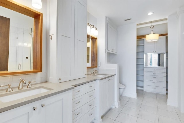 800 W 5th St Unit 1008, Austin, TX 78703 - full bath with double vanity, toilet, tile patterned floors, a spacious closet, and tasteful backsplash