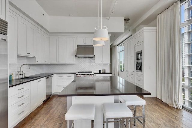 800 W 5th St Unit 1008, Austin, TX 78703 - kitchen featuring a sink, under cabinet range hood, dark countertops, and appliances with stainless steel finishes