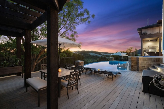 3708 Lajitas, Leander, TX 78641 - deck at dusk featuring outdoor dining area, a pergola, and an infinity pool
