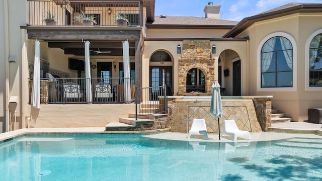 3708 Lajitas, Leander, TX 78641 - back of property with a balcony, an outdoor pool, a chimney, and stone siding