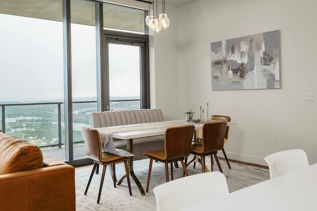 44 E Ave Unit 4305, Austin, TX 78701 - dining space with healthy amount of natural light, light wood-type flooring, baseboards, a wall of windows, and a chandelier