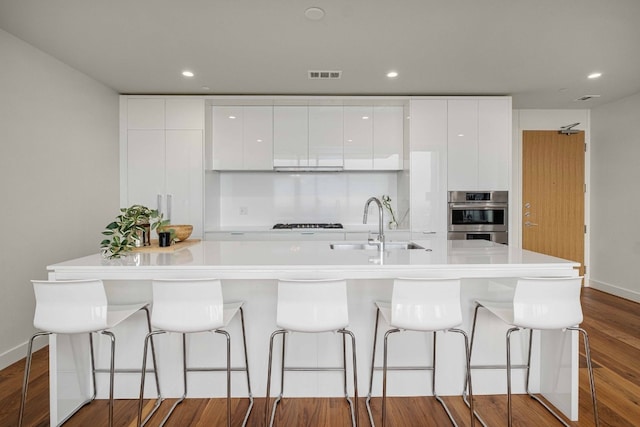 44 E Ave Unit 4305, Austin, TX 78701 - kitchen with modern cabinets, a sink, white cabinets, a spacious island, and dark wood-type flooring