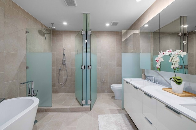 44 E Ave Unit 4305, Austin, TX 78701 - full bathroom with tile walls, a shower stall, double vanity, a freestanding bath, and tile patterned floors