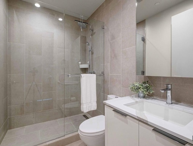 44 E Ave Unit 4305, Austin, TX 78701 - bathroom featuring toilet, vanity, a tile shower, tile walls, and recessed lighting