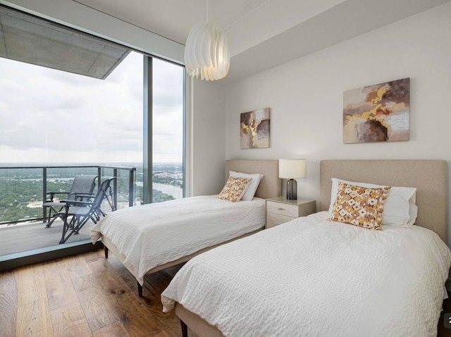 44 E Ave Unit 4305, Austin, TX 78701 - bedroom featuring wood finished floors, multiple windows, a wall of windows, and access to outside