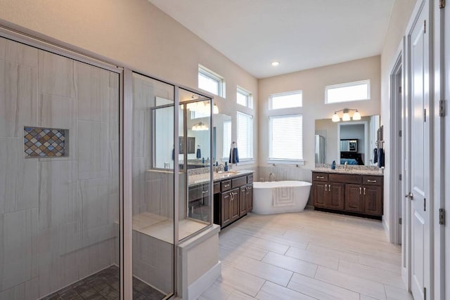 629 Asher Ct, Leander, TX 78641 - full bathroom with a stall shower, a freestanding bath, two vanities, and recessed lighting