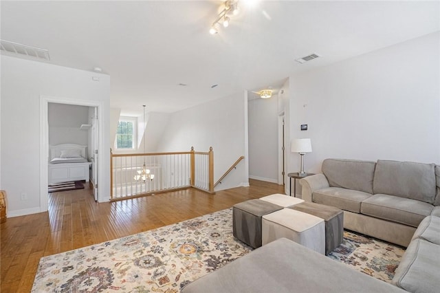 living room with wood finished floors, baseboards, and track lighting