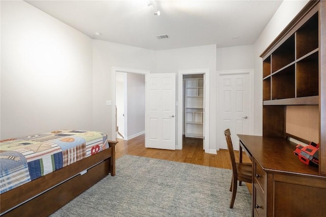 bedroom featuring wood finished floors, a desk, and baseboards