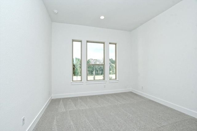 carpeted spare room featuring baseboards and recessed lighting