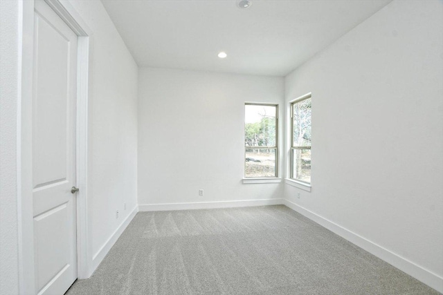 carpeted empty room featuring baseboards and recessed lighting