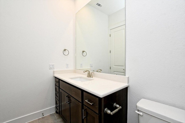 bathroom with baseboards, visible vents, vanity, and toilet