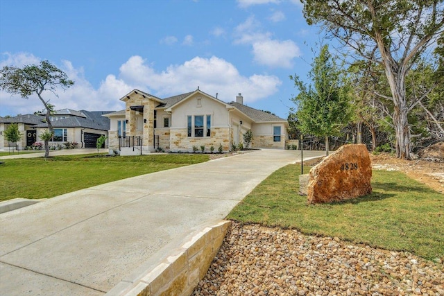 view of front of house with a chimney, concrete driveway, stucco siding, stone siding, and a front yard