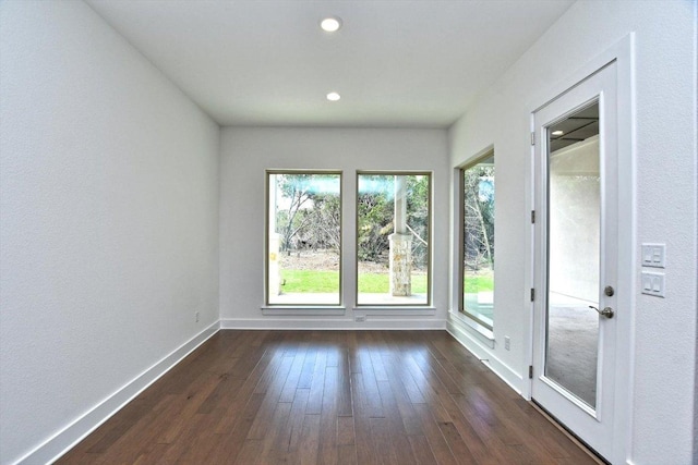 spare room featuring dark wood-type flooring, baseboards, and recessed lighting
