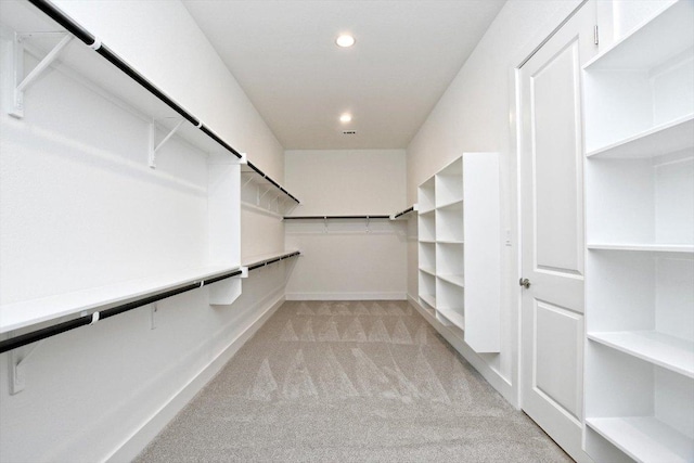 walk in closet featuring light colored carpet