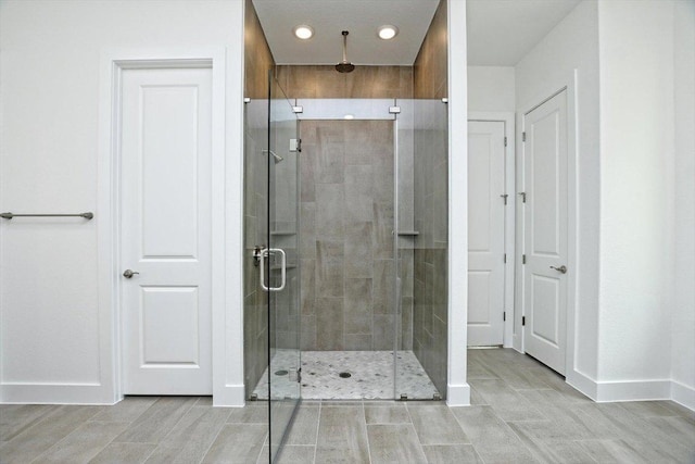 bathroom featuring baseboards, recessed lighting, and a shower stall