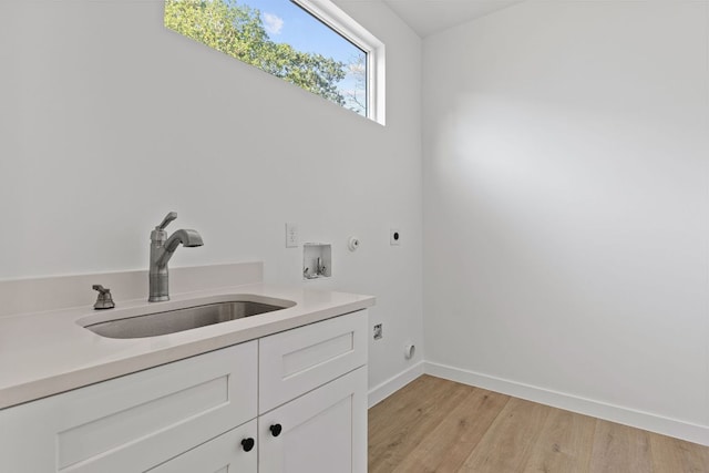 208 Ulupau Cir, Bastrop, TX 78602 - laundry area featuring hookup for an electric dryer, cabinet space, washer hookup, light wood-type flooring, and baseboards