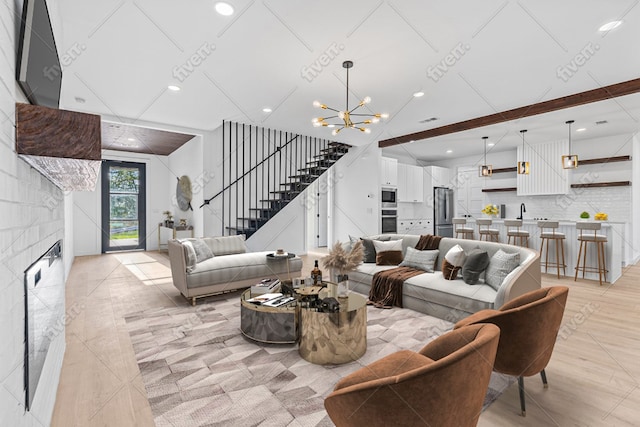 208 Ulupau Cir, Bastrop, TX 78602 - living room with stairway, a chandelier, a large fireplace, and recessed lighting