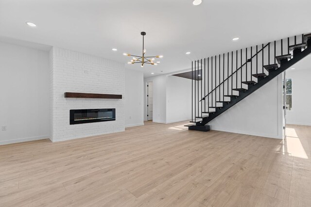208 Ulupau Cir, Bastrop, TX 78602 - unfurnished living room featuring a chandelier, wood finished floors, baseboards, stairway, and recessed lighting