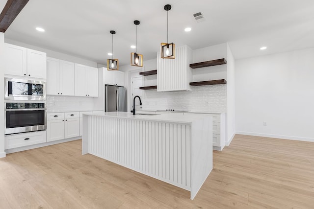 208 Ulupau Cir, Bastrop, TX 78602 - kitchen featuring stainless steel appliances, open shelves, tasteful backsplash, light countertops, and light wood finished floors