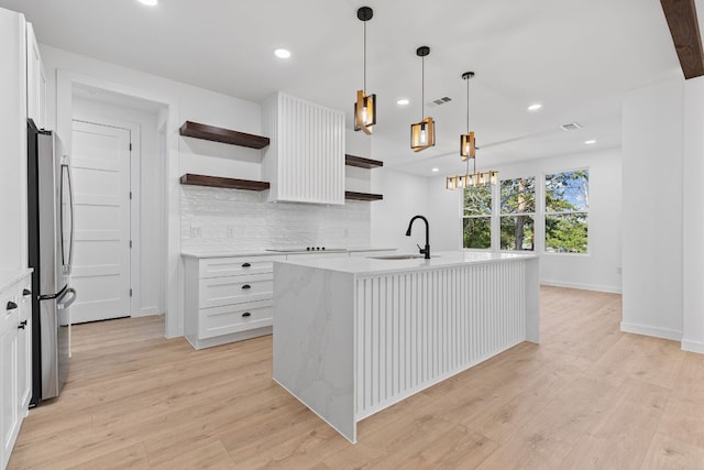 208 Ulupau Cir, Bastrop, TX 78602 - kitchen featuring open shelves, freestanding refrigerator, tasteful backsplash, light wood-style flooring, and recessed lighting