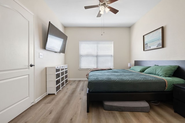 bedroom featuring a ceiling fan, baseboards, and light wood-style floors