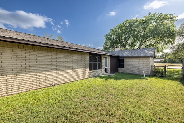 110 Live Oak St, Gonzales, TX 78629 - back of house with a chimney, a gate, fence, a yard, and brick siding