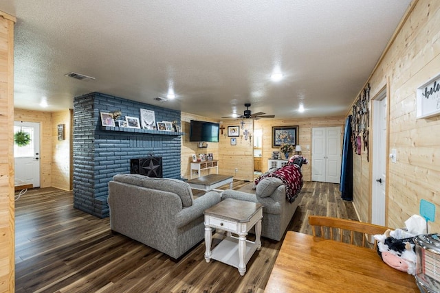 110 Live Oak St, Gonzales, TX 78629 - living room featuring a brick fireplace, wood finished floors, wooden walls, and a ceiling fan