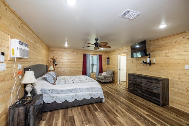 110 Live Oak St, Gonzales, TX 78629 - bedroom with a wall mounted air conditioner, a ceiling fan, wood finished floors, wooden walls, and visible vents