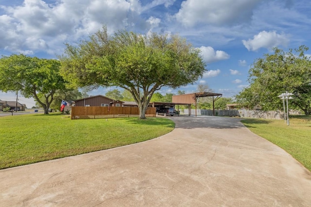 110 Live Oak St, Gonzales, TX 78629 - view of front of property featuring fence, a front lawn, driveway, and a carport