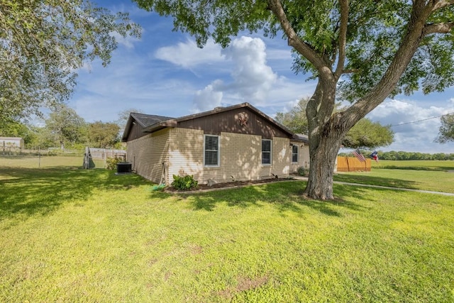 110 Live Oak St, Gonzales, TX 78629 - view of side of home featuring fence, a yard, and central air condition unit