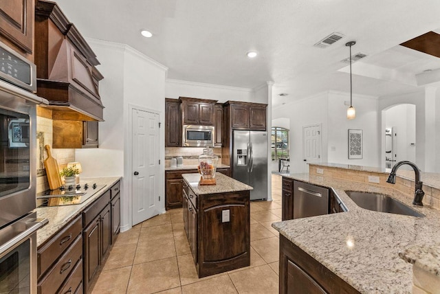 kitchen with visible vents, a center island, stainless steel appliances, and a sink