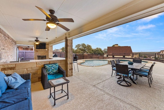 view of patio / terrace with a ceiling fan, a fenced backyard, a fenced in pool, and a sink