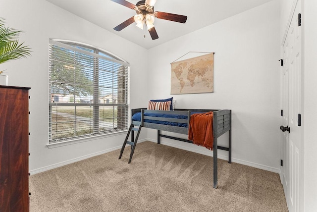 carpeted bedroom with baseboards and ceiling fan