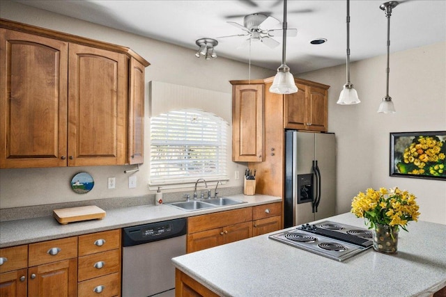 kitchen featuring a sink, decorative light fixtures, a center island, appliances with stainless steel finishes, and ceiling fan