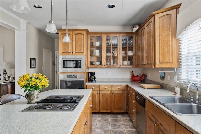 kitchen featuring appliances with stainless steel finishes, a sink, light countertops, and glass insert cabinets