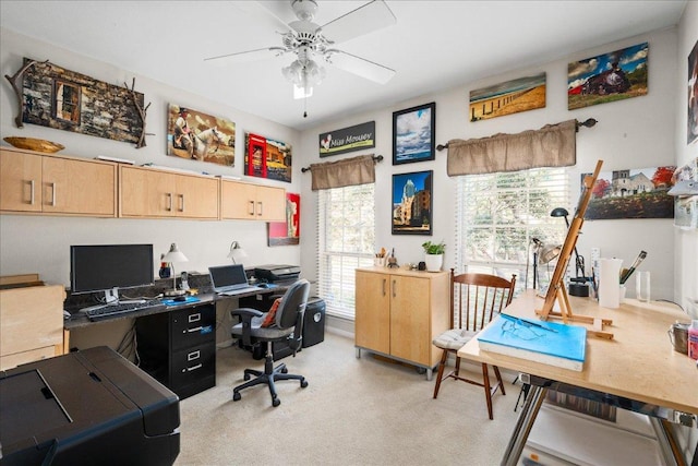 office space with a ceiling fan and light colored carpet