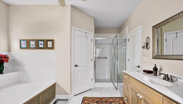 bathroom with baseboards, tile patterned flooring, a shower stall, a garden tub, and vanity