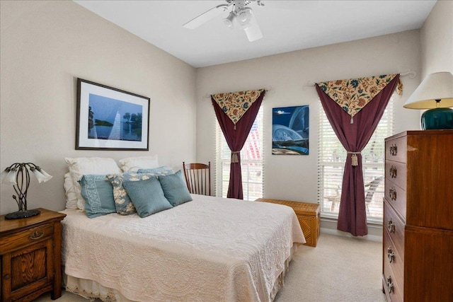 bedroom with light carpet, a ceiling fan, and multiple windows