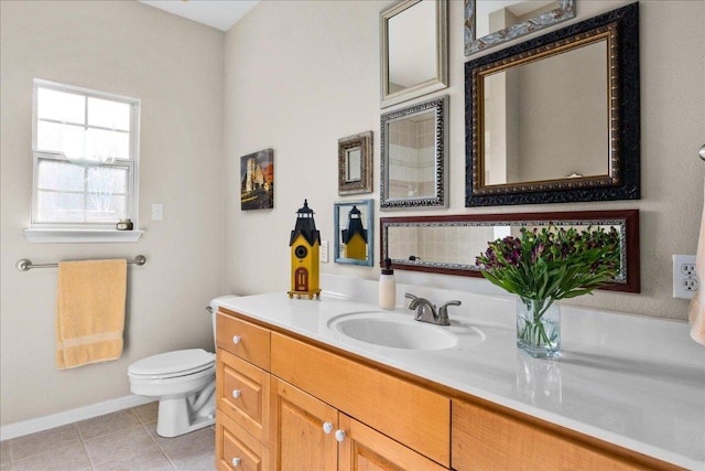 bathroom featuring tile patterned floors, baseboards, vanity, and toilet