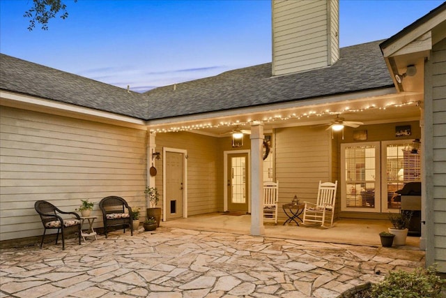 rear view of house featuring a chimney, a ceiling fan, a patio, and a shingled roof