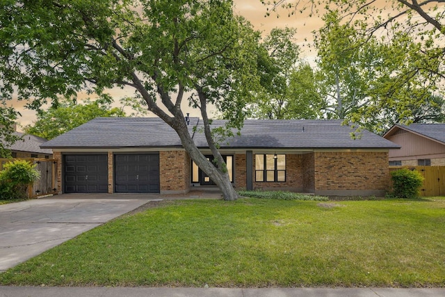 1337 Neans Dr, Austin, TX 78758 - view of front of property with fence, a front lawn, concrete driveway, an attached garage, and brick siding