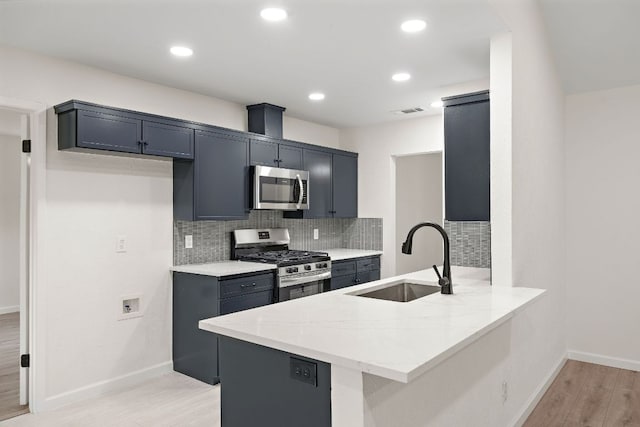 1337 Neans Dr, Austin, TX 78758 - kitchen featuring stainless steel appliances, a sink, a peninsula, light stone countertops, and light wood-style floors