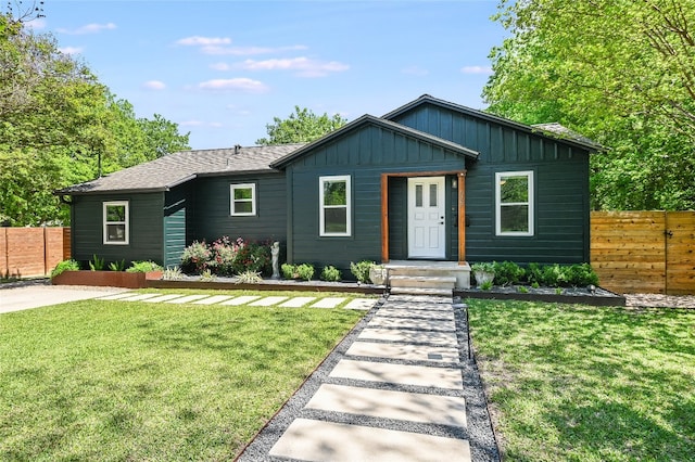 6307 Camino Real Unit 1, Austin, TX 78757 - view of front of house featuring fence, a front lawn, and board and batten siding