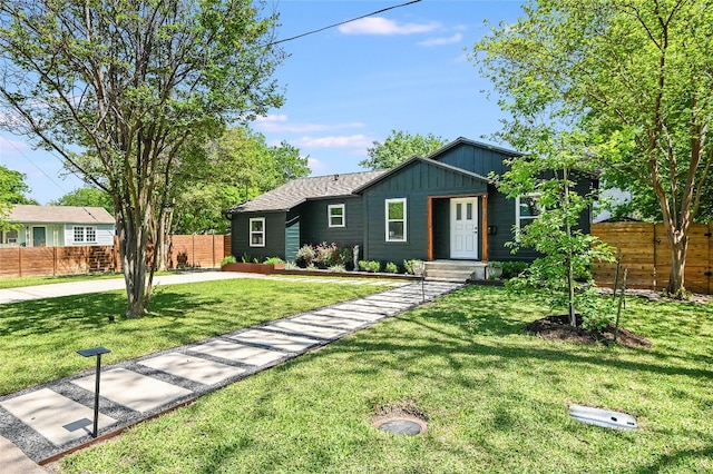6307 Camino Real Unit 1, Austin, TX 78757 - view of front of property with board and batten siding, a front yard, and fence