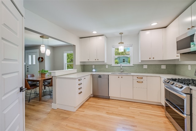 6307 Camino Real Unit 1, Austin, TX 78757 - kitchen with light countertops, pendant lighting, a sink, and appliances with stainless steel finishes