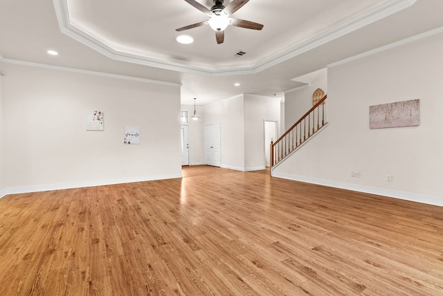2800 Lomas Rodando Calzada Rd, Kempner, TX 76539 - unfurnished living room featuring a raised ceiling, a ceiling fan, stairway, light wood-style floors, and ornamental molding