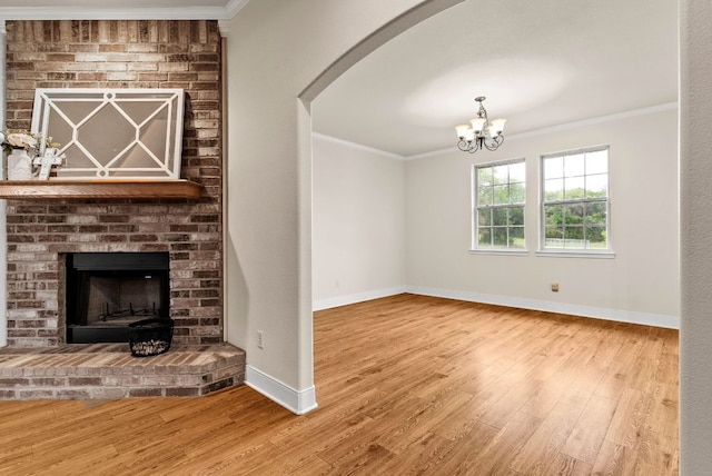 2800 Lomas Rodando Calzada Rd, Kempner, TX 76539 - unfurnished living room with crown molding, wood finished floors, baseboards, arched walkways, and a brick fireplace