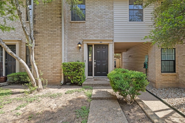 doorway to property featuring brick siding