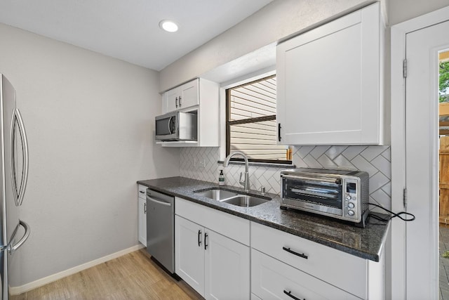8400 Jamestown Dr Unit 410, Austin, TX 78758 - kitchen with stainless steel appliances, backsplash, white cabinets, and light wood-style floors