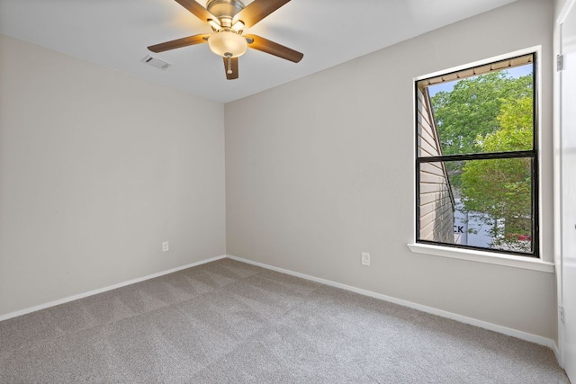 spare room featuring baseboards, visible vents, carpet, and ceiling fan